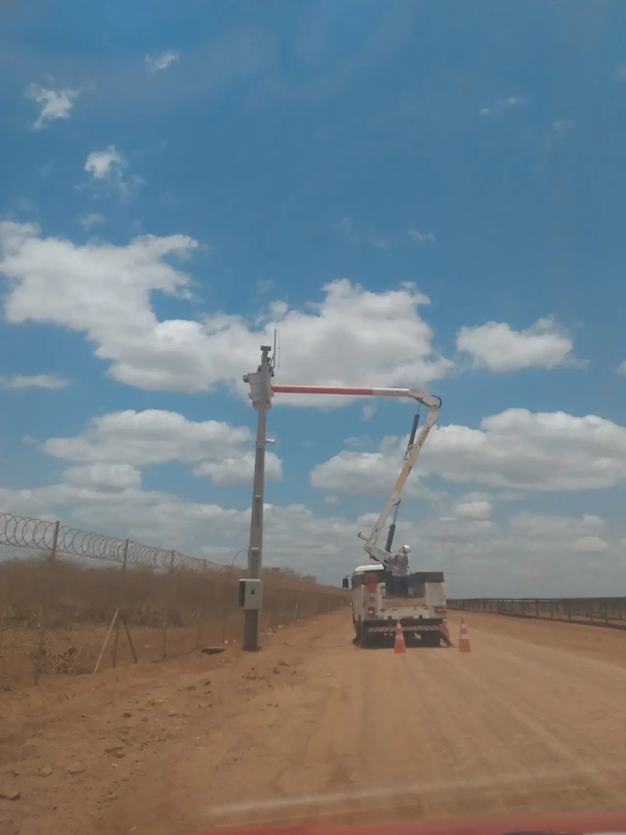 Caminhão munck instalando câmera de segurança em poste
